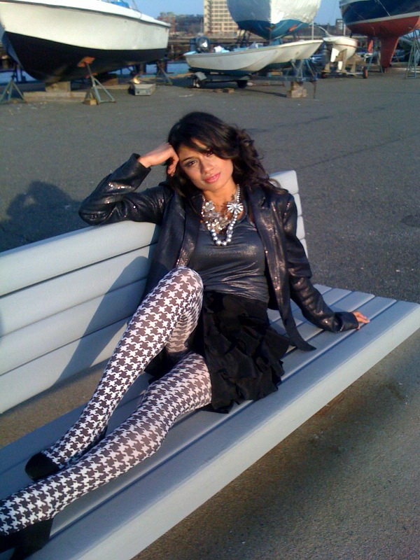 Diane Guerrero on a bench in tights