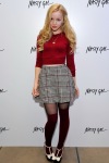 Dove Cameron wearing a skirt and pantyhose