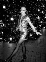 Lily-Rose Depp wearing a miniskirt and black shirt tights