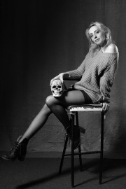 Maria Bello on a stool in black tights