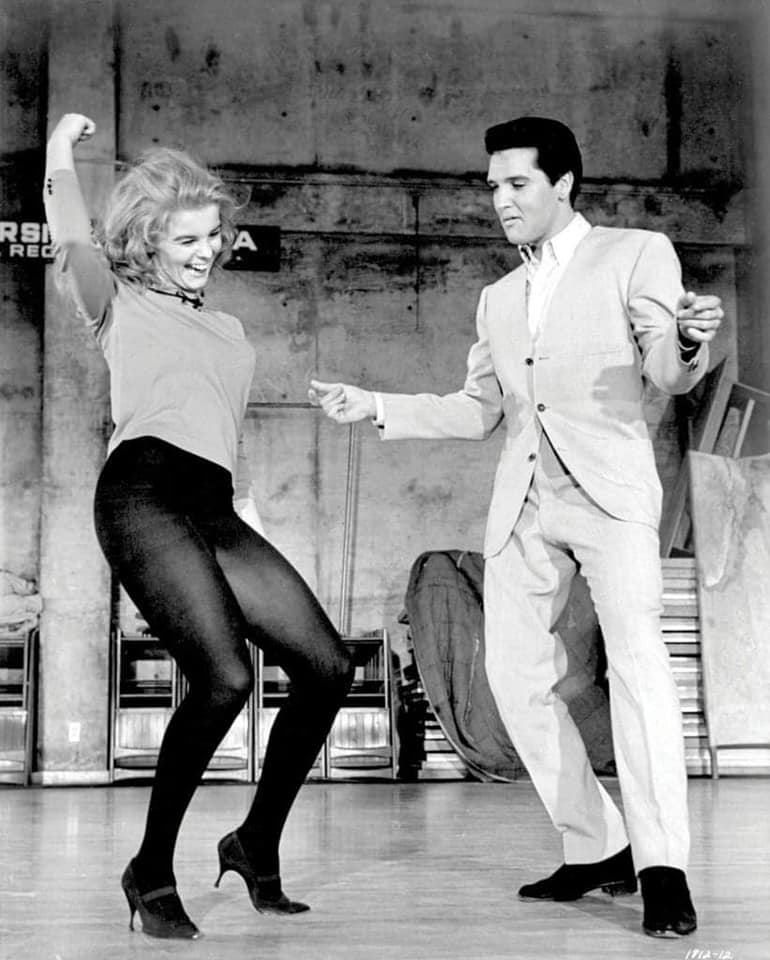 Ann-Margret dancing energetically with Elvis Presley in opaque tights.