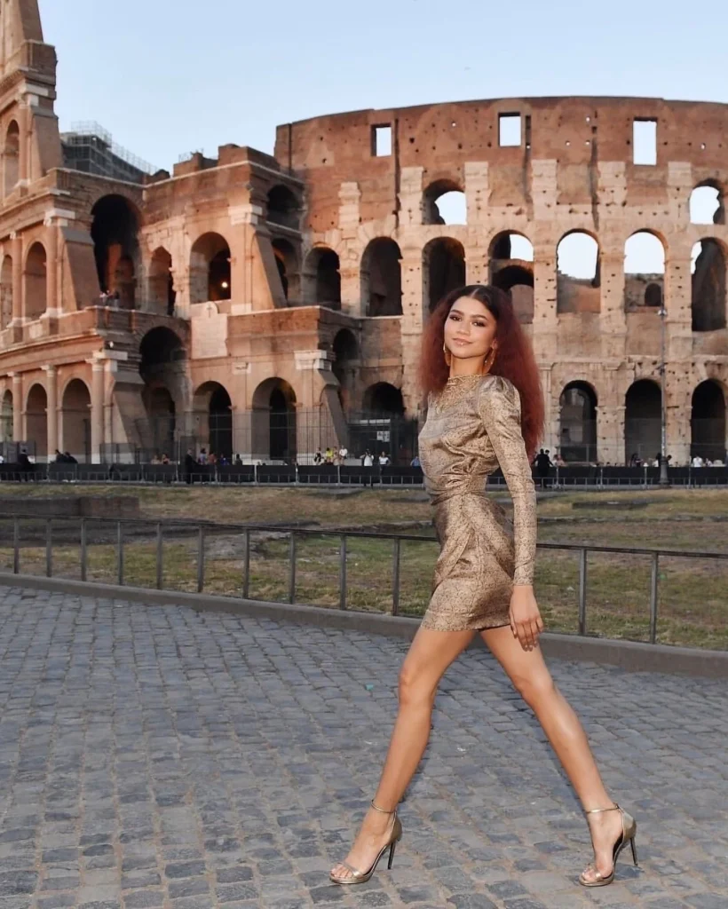 Zendaya in a gold dress and golden heels near the Colosseum